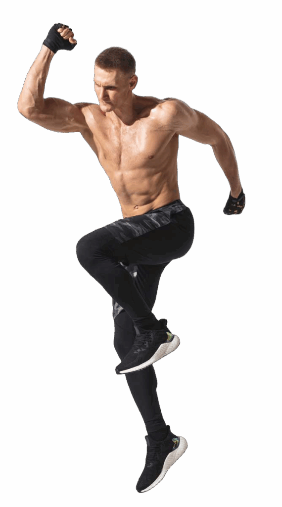 Hombre atlético sin camisa saltando con brazo flexionado, usando guantes y ropa deportiva ajustada en color negro.