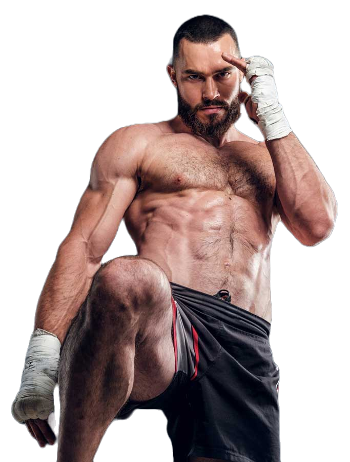 Hombre musculoso con vendas en las manos y short negro, en pose de combate con mirada intensa.